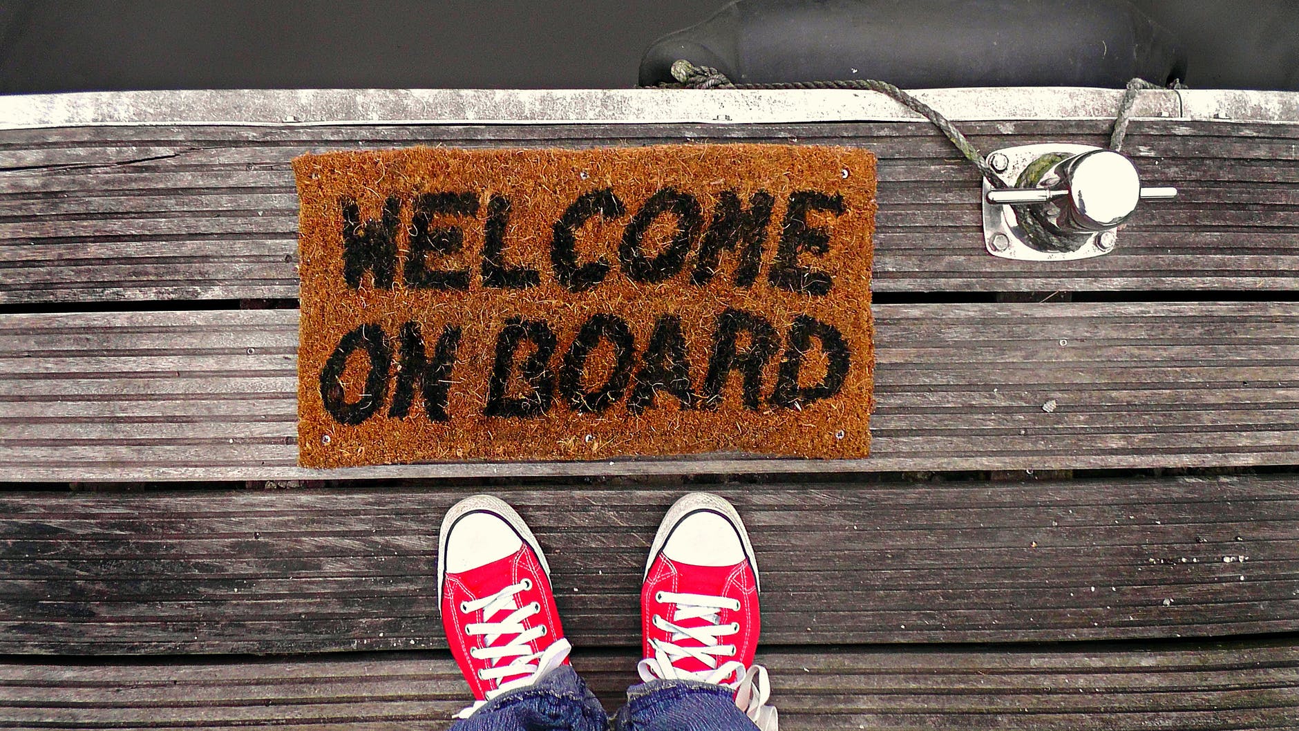 person standing near brown welcome on board printed floor map