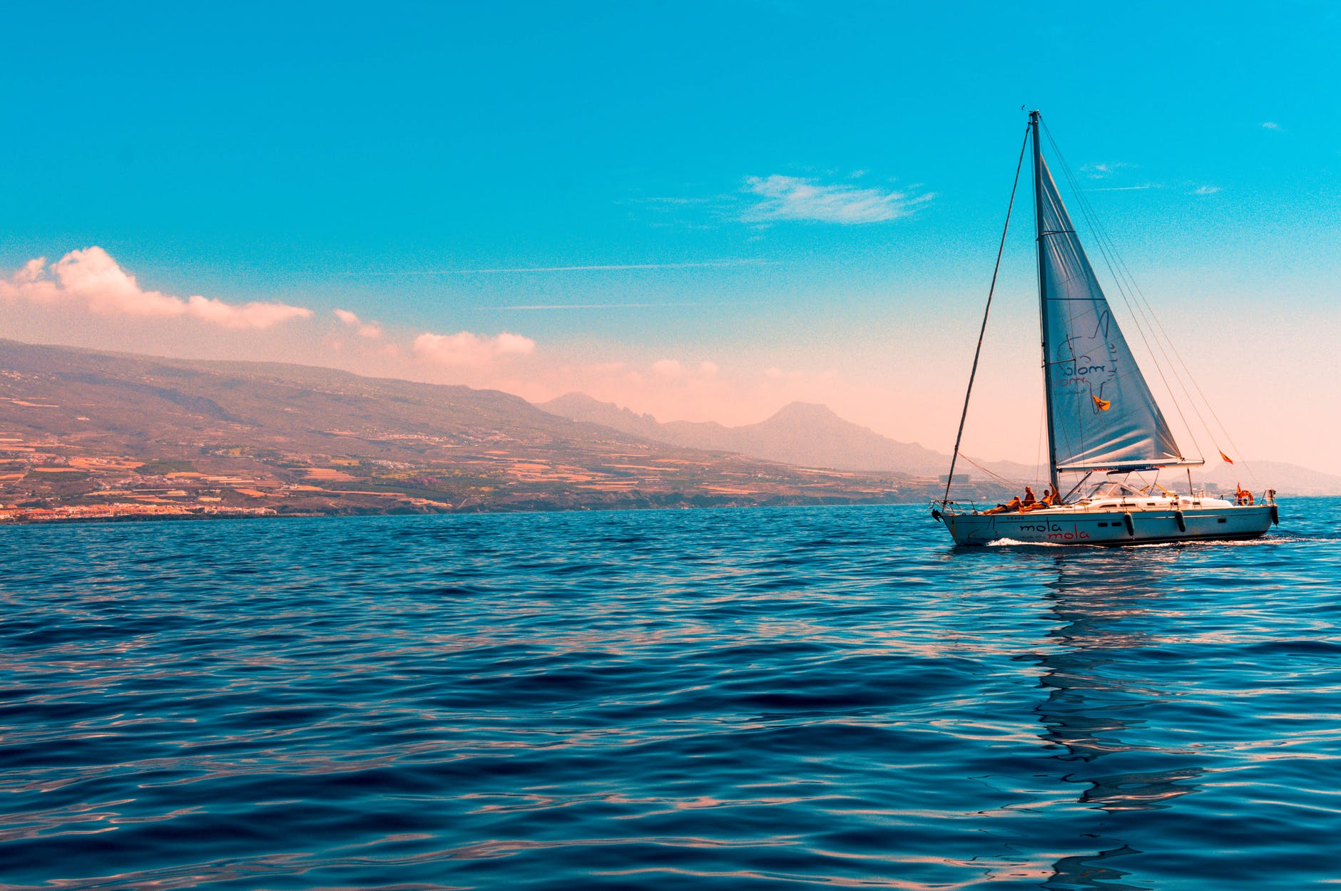 sailboat sailing on water near island The Yacht Chef